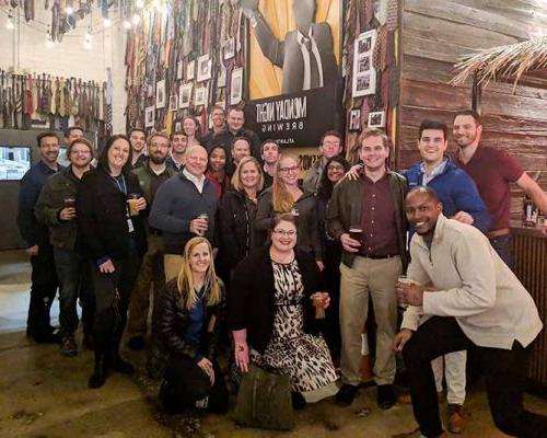 澳门足彩app Atlanta employees pose for an on-boarding dinner photo